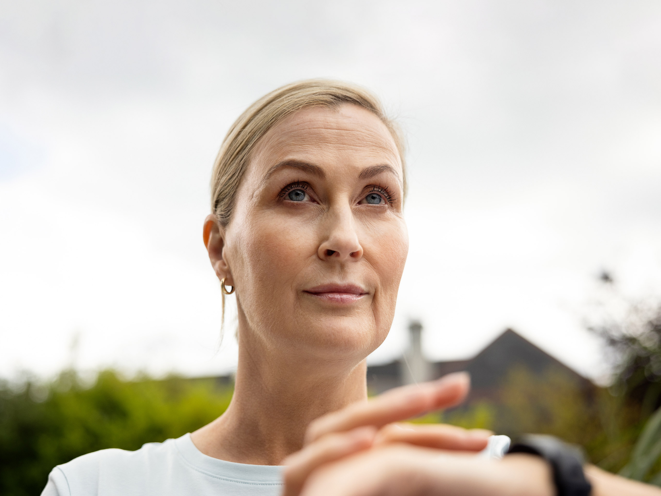 Portrait of a woman outdoors, attentively checking her smartwatch.