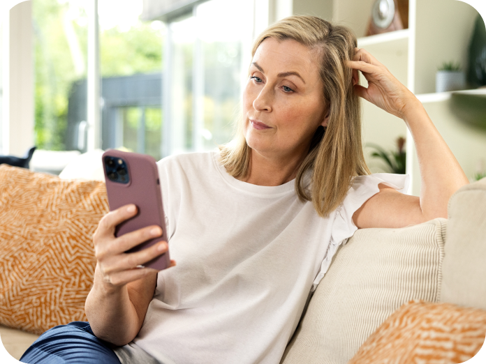 Woman sitting on sofa using her smartphone
