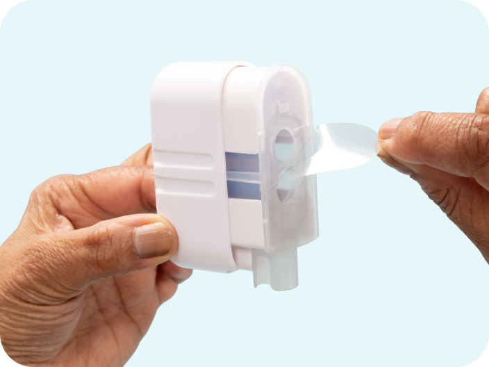 Clear plastic strip being peeled off by using the tab at the top of the Impress device.