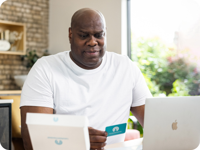 Man reading the instructions provided in the Letsgetchecked kit. 