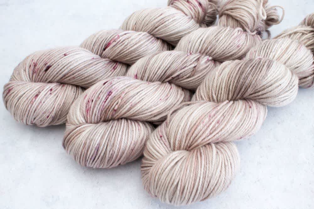 Three beige and purple toned yarn skeins inspired by Rey’s Jakku origins