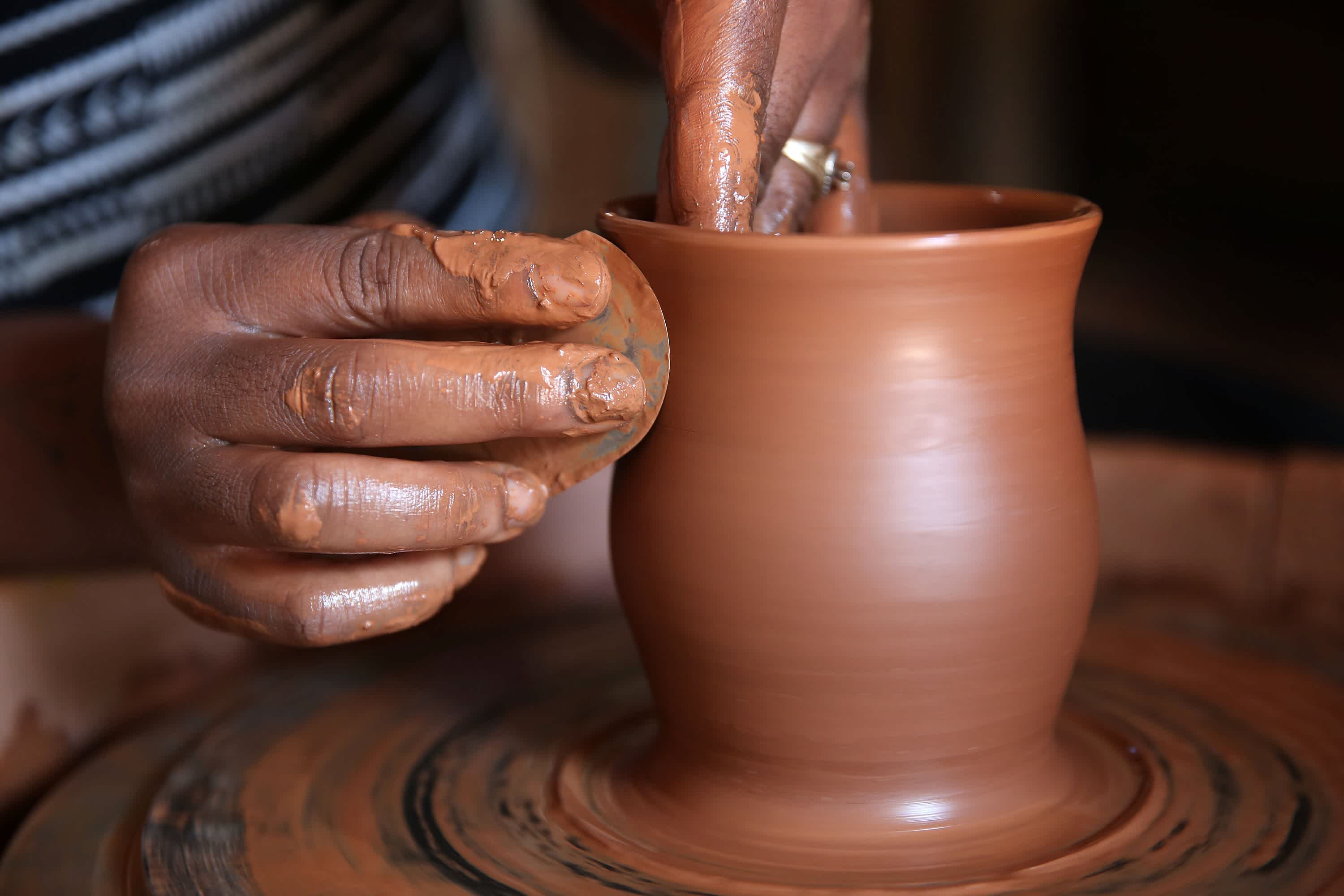 Hands spinning clay to make a vase