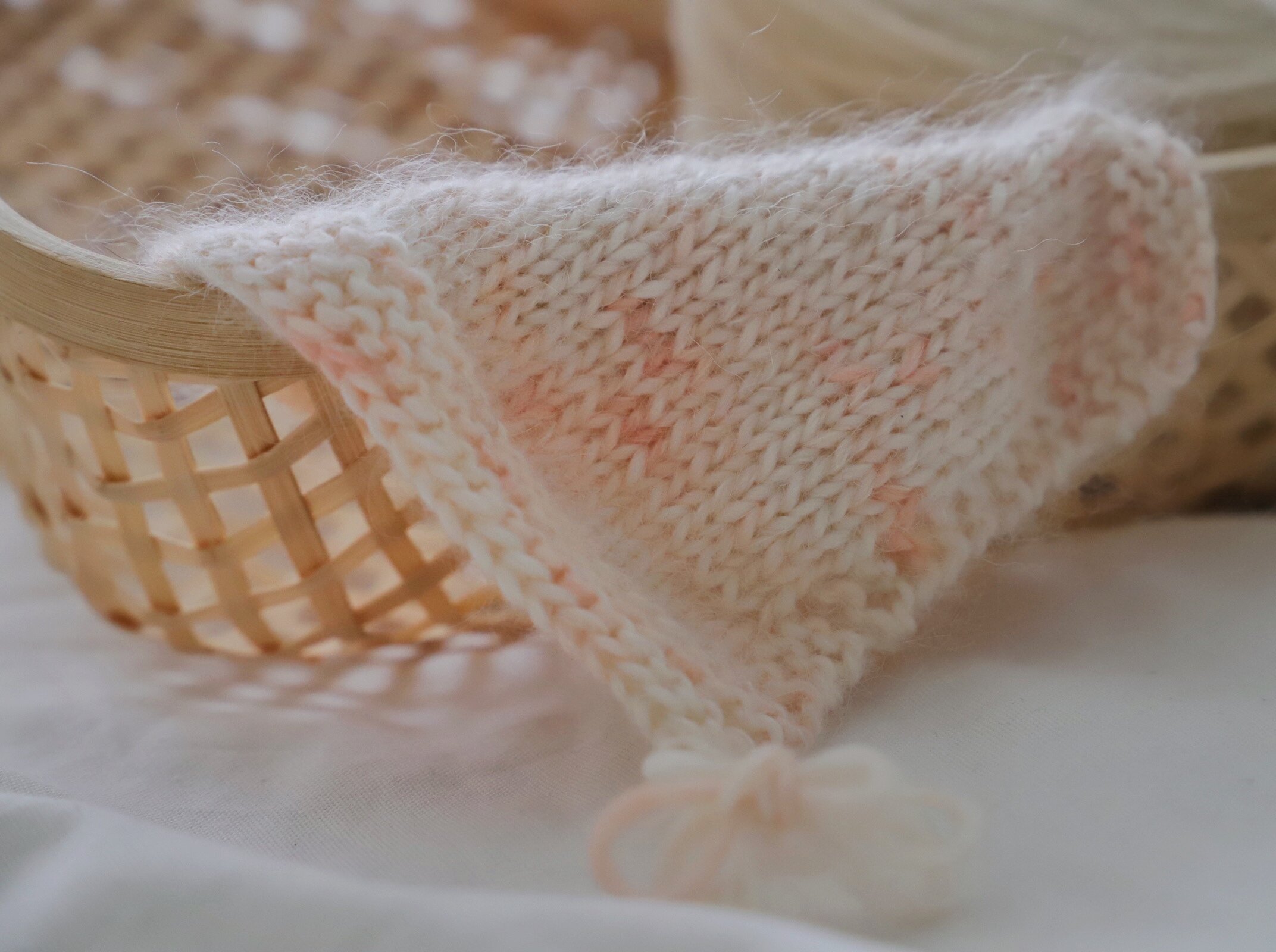 Soft pink knitted swatch in basket