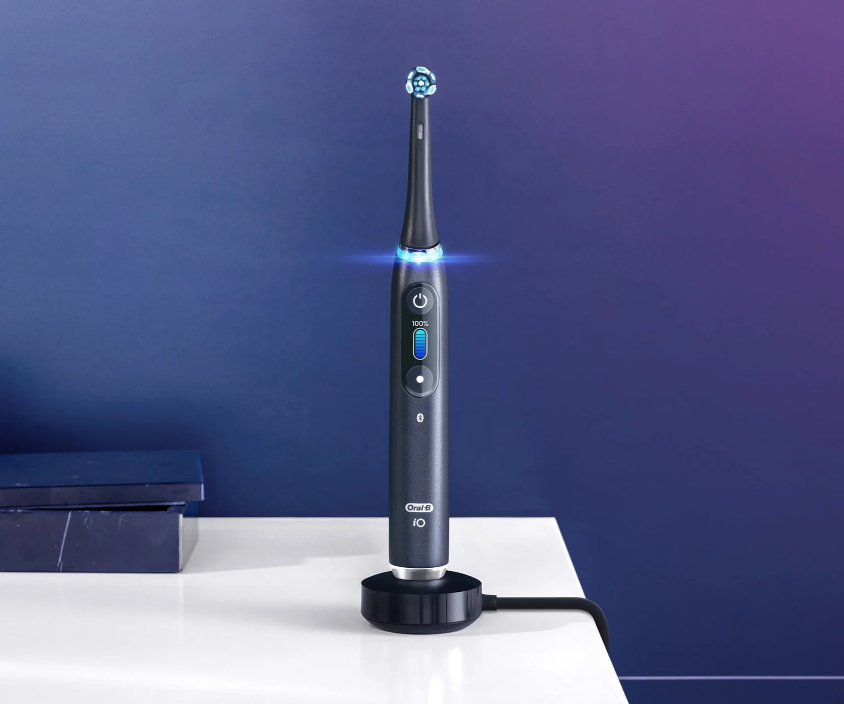 Black Oral-B iO9 electric toothbrush on magnetic charger 