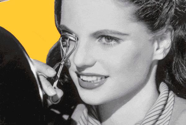 Vintage photo of a young woman getting her eyelashed curled with a metal curling tool