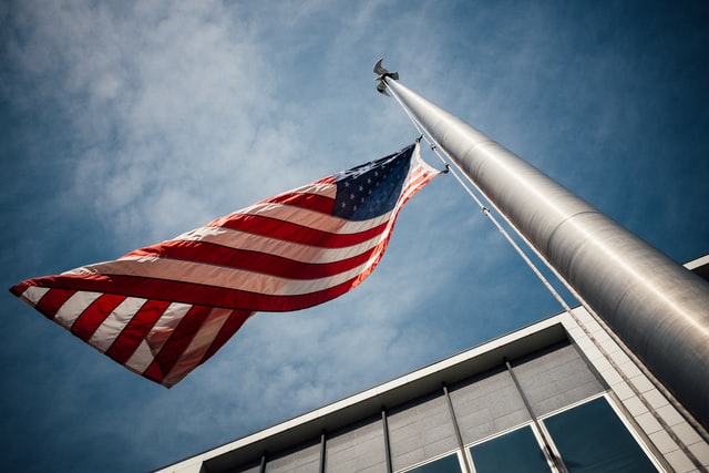 a red and white flag flying on a flagpole