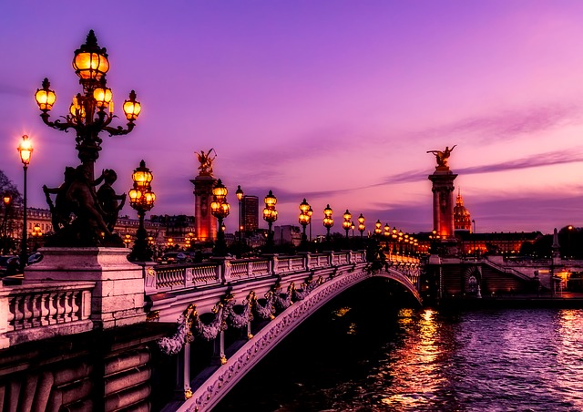 a bridge with a body of water and a bridge with statues on it