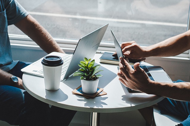 a man and a woman using laptops