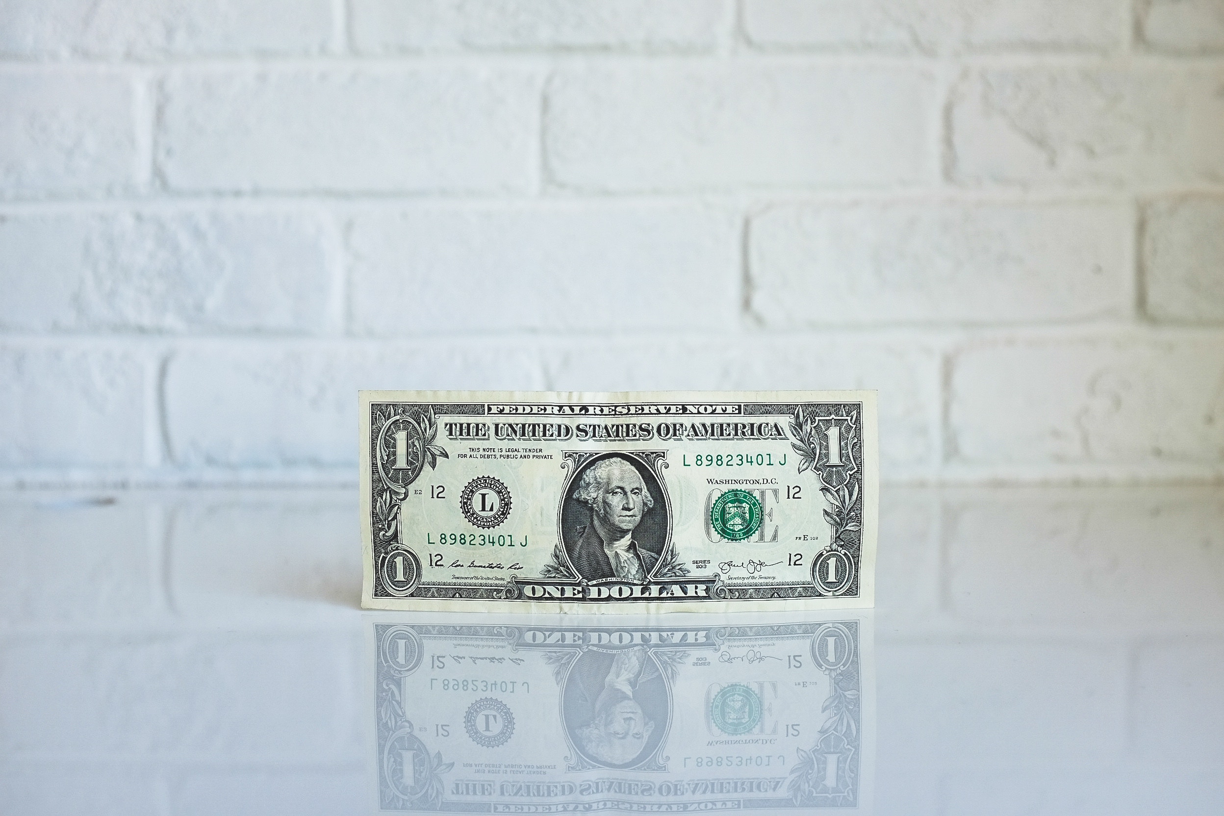 a dollar bill on a white surface
