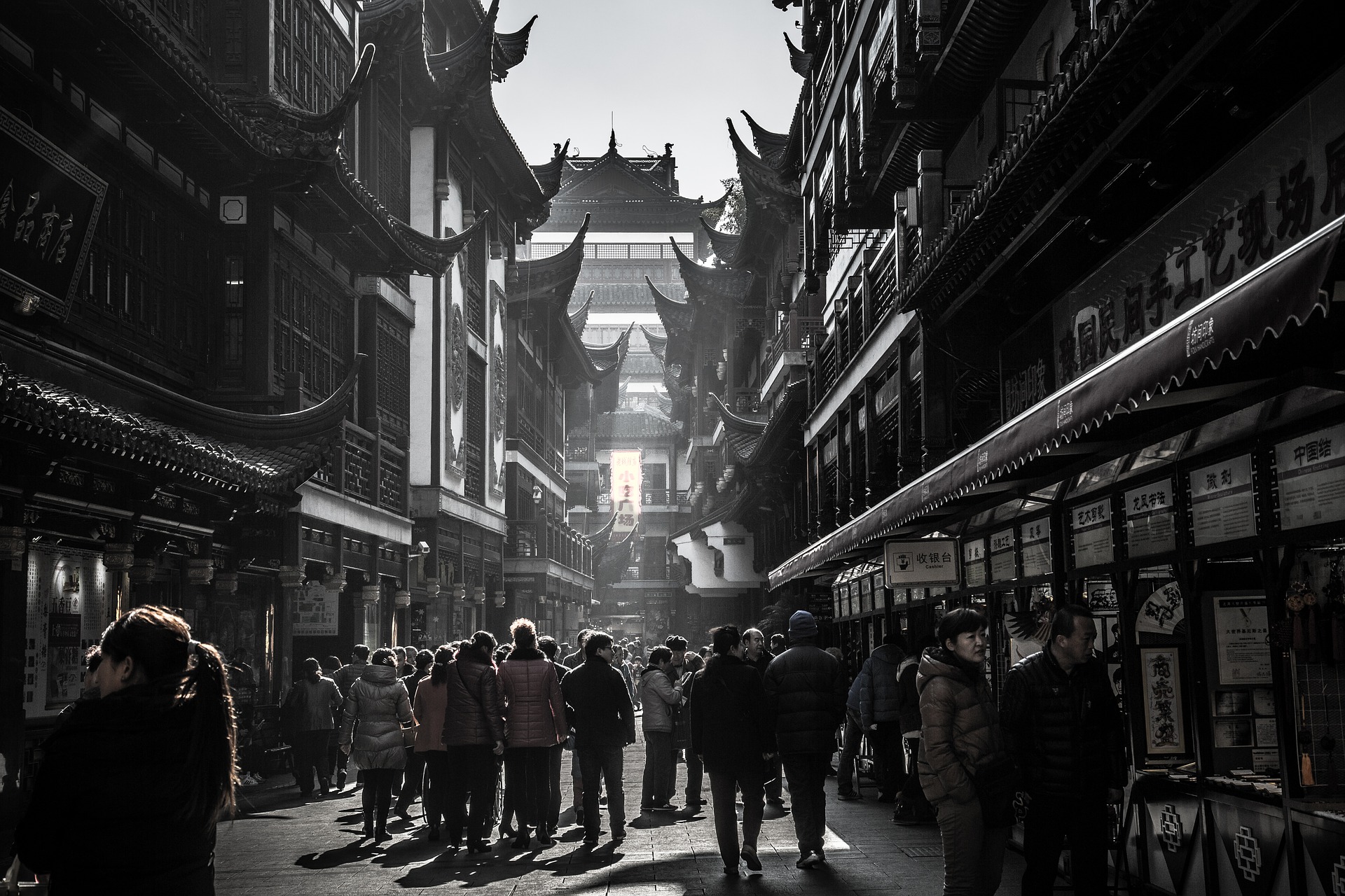 a crowd of people walking down a street between buildings