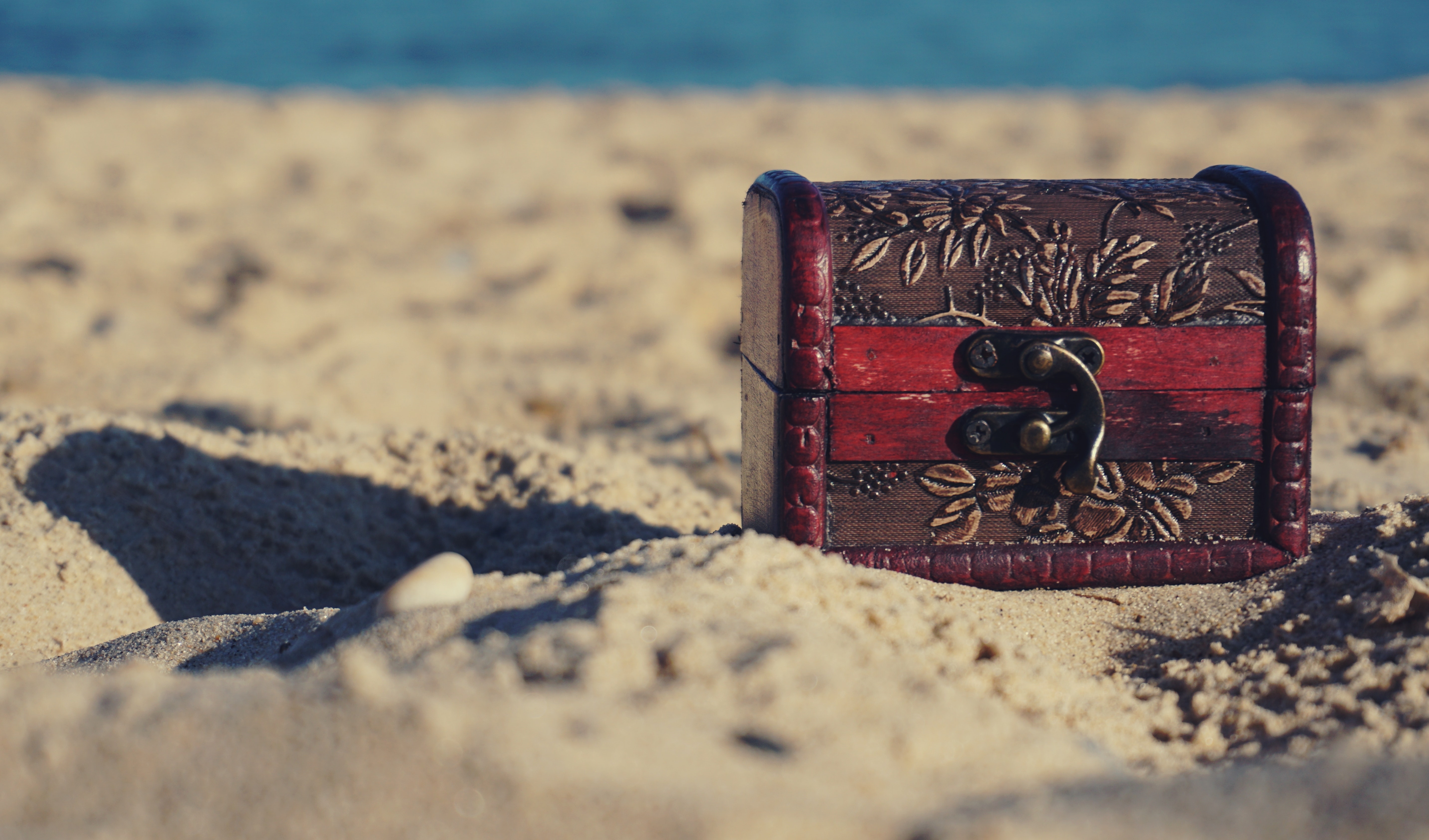 a red metal object on sand