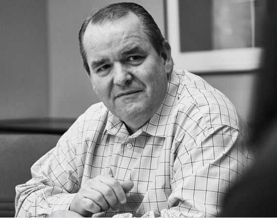 a man sitting down and holding a cup