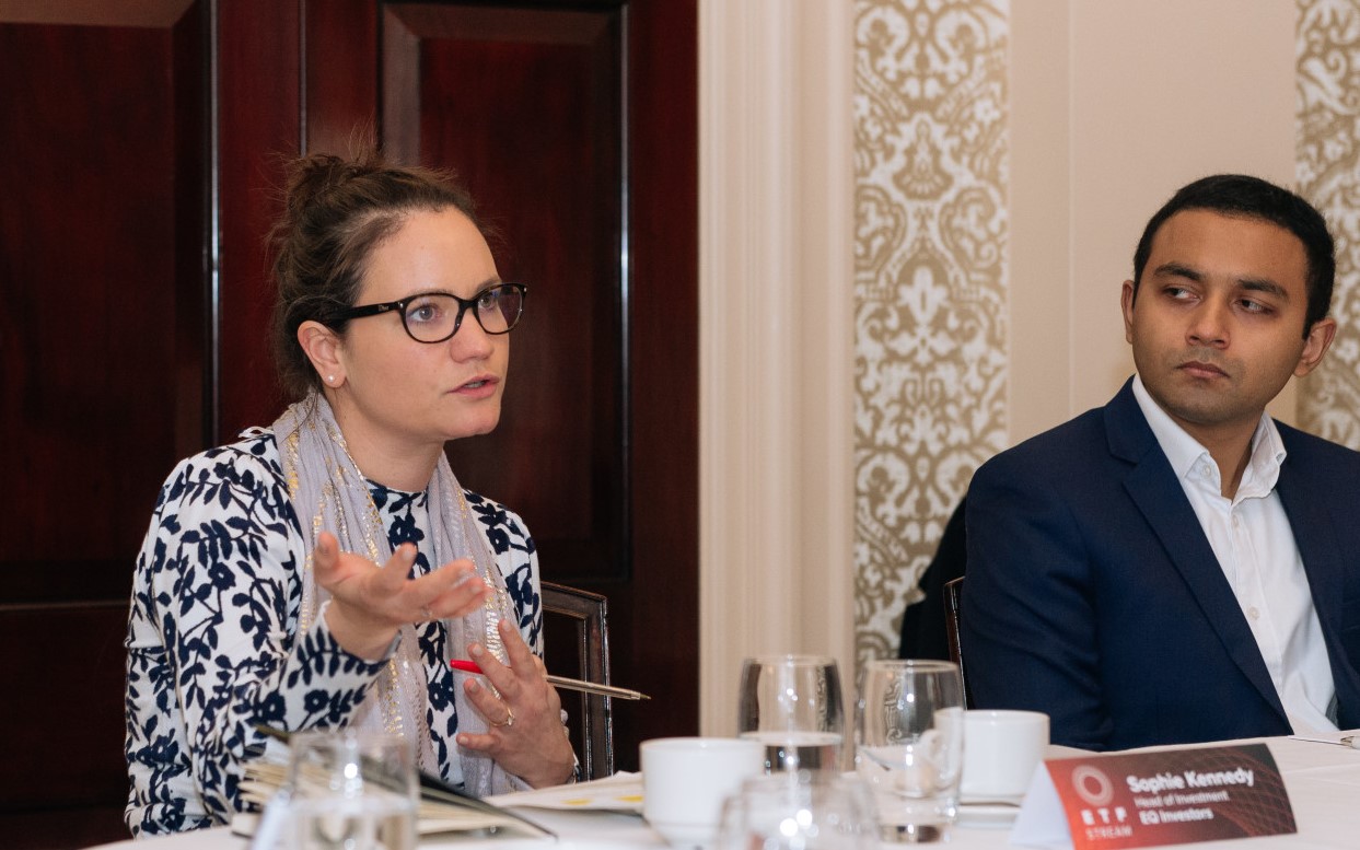 a man and a woman sitting at a table with glasses and papers