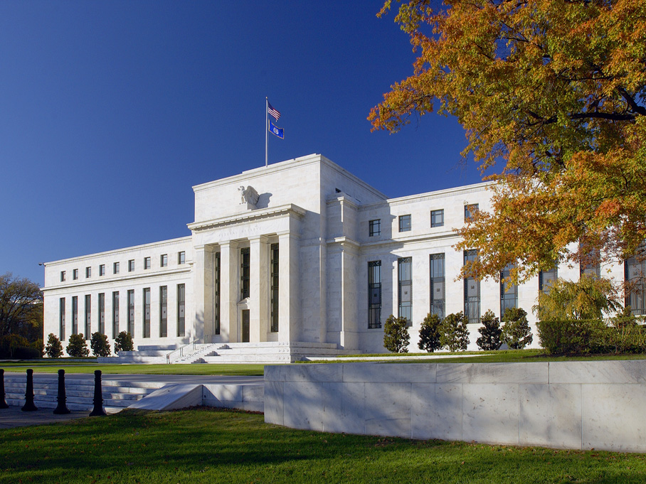 a white building with columns and a flag on top