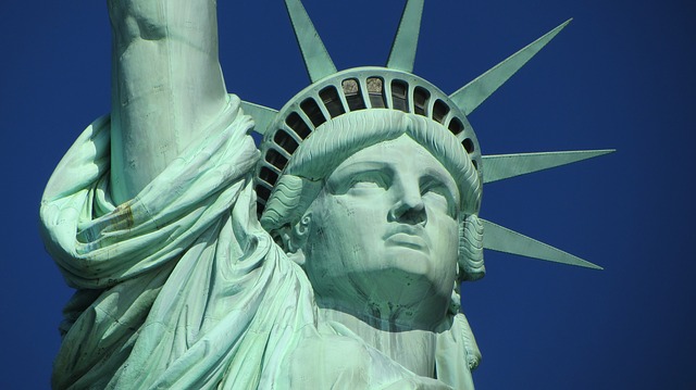 a statue of liberty with a blue sky with Statue of Liberty in the background