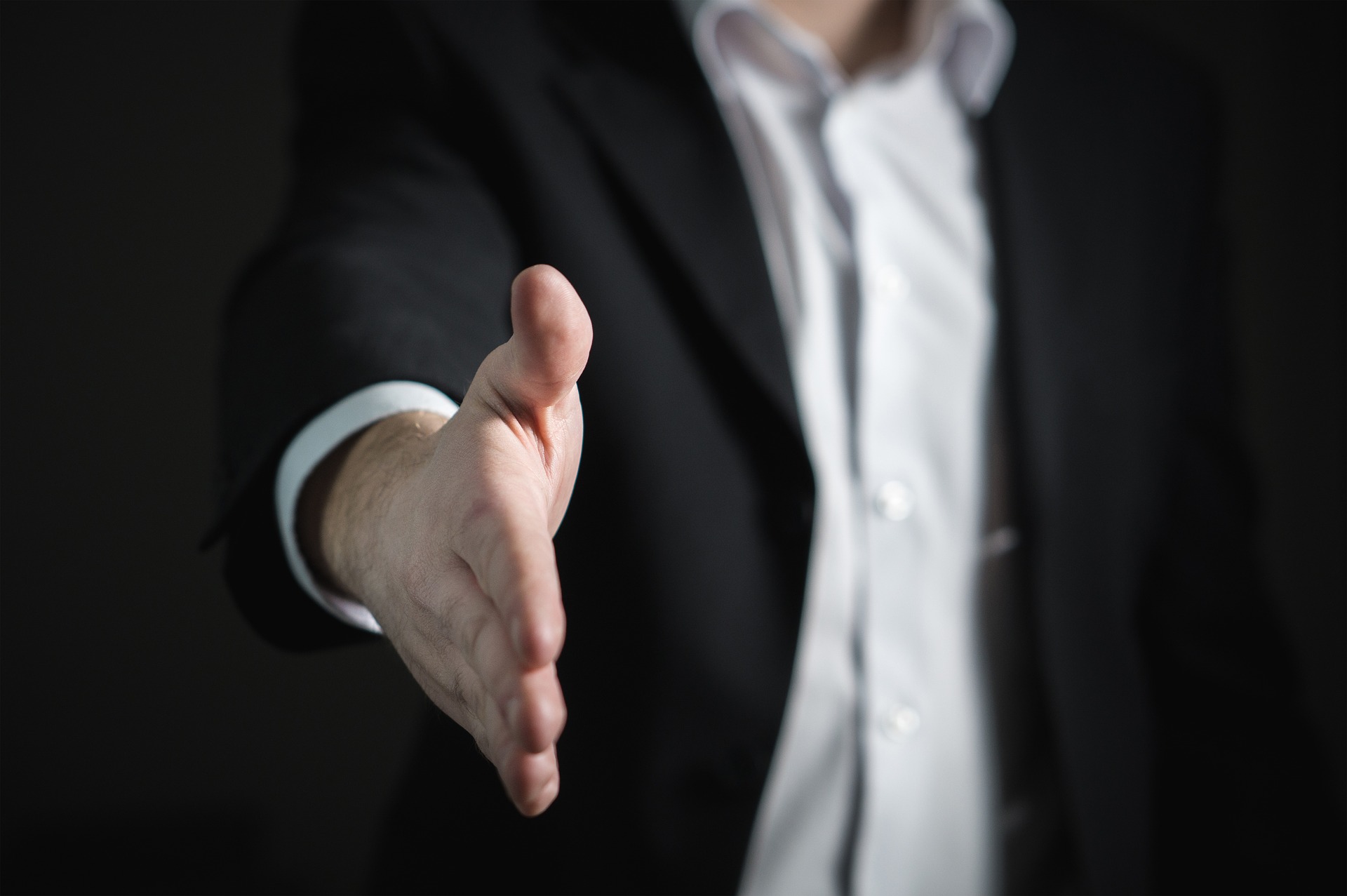 a man in a suit holding his hand up