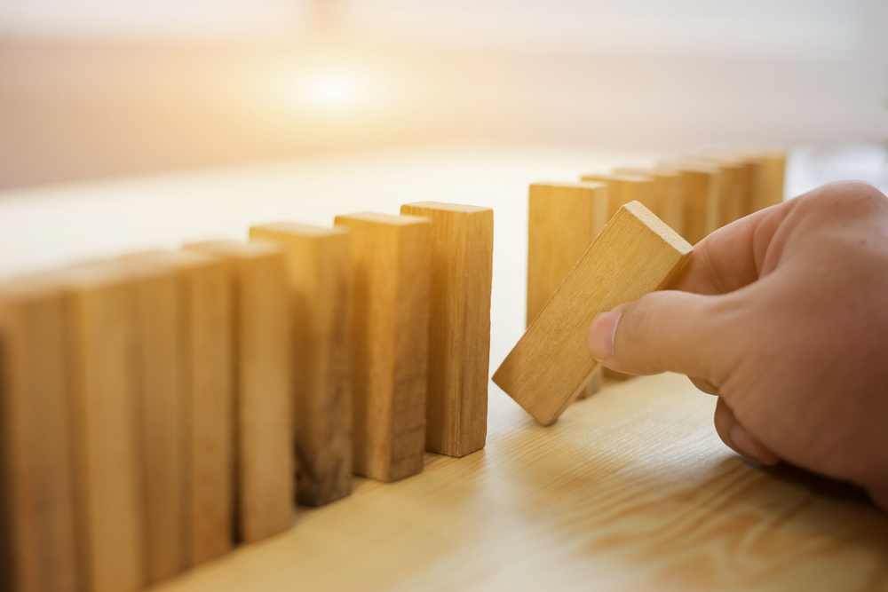 a hand holding a wooden block