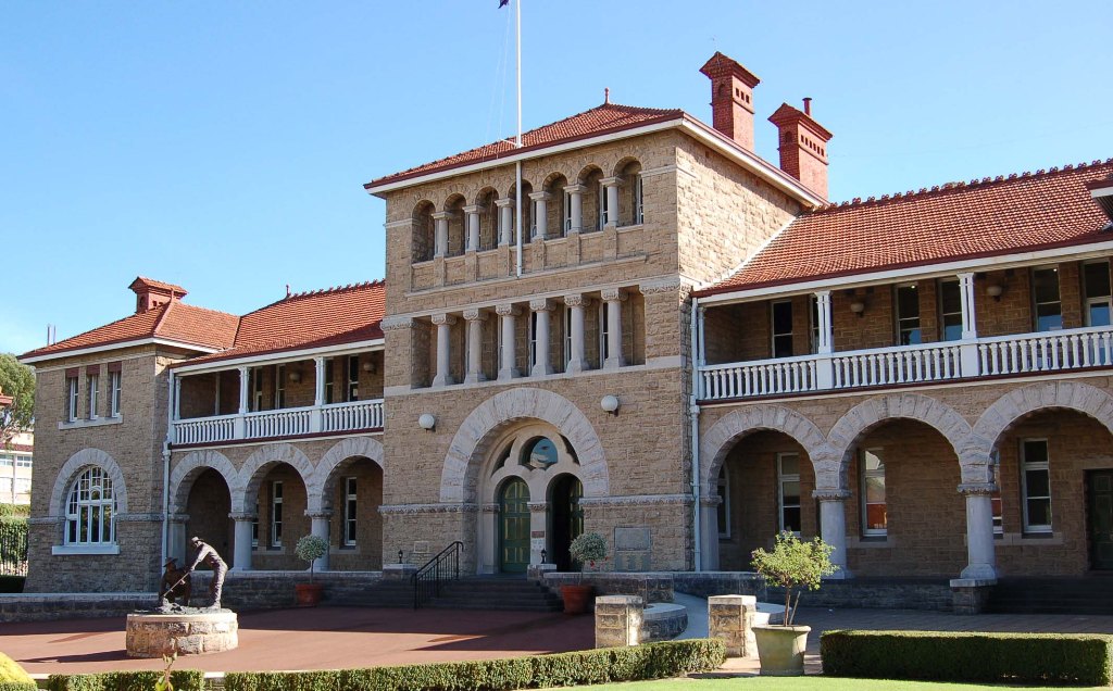 a large building with a large courtyard with Perth Mint in the background