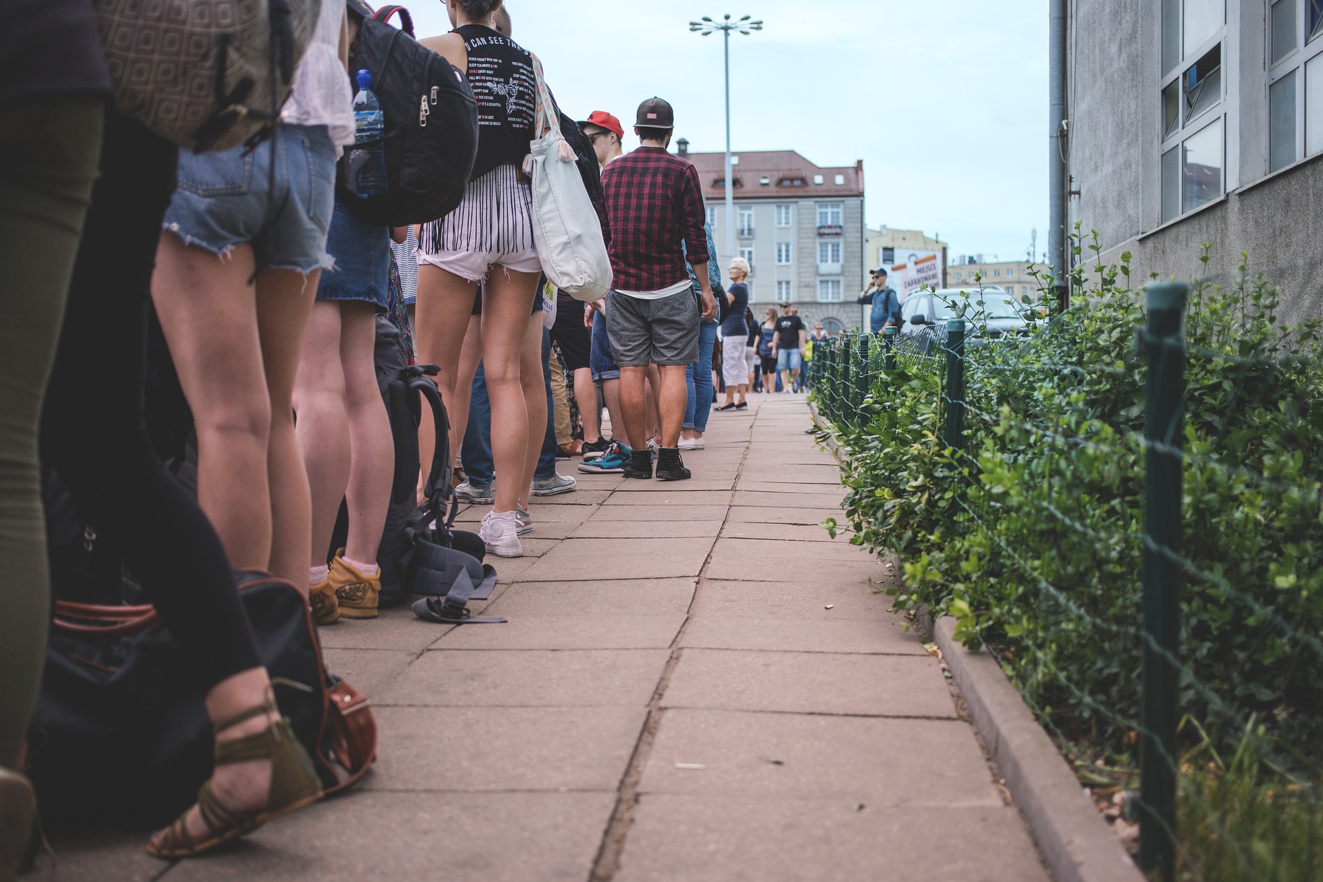 a group of people standing on a sidewalk