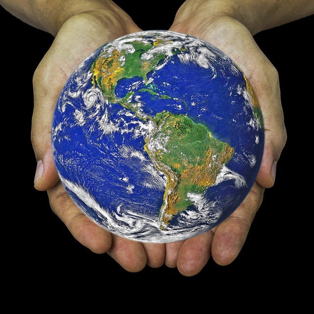 a pair of hands holding a blue globe