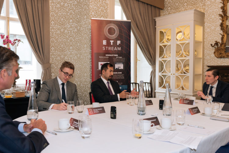 a group of people sitting at a table with wine glasses and a sign