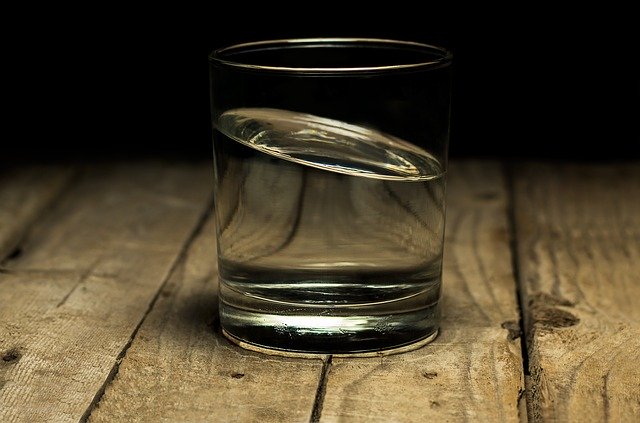 a glass of water on a wood surface