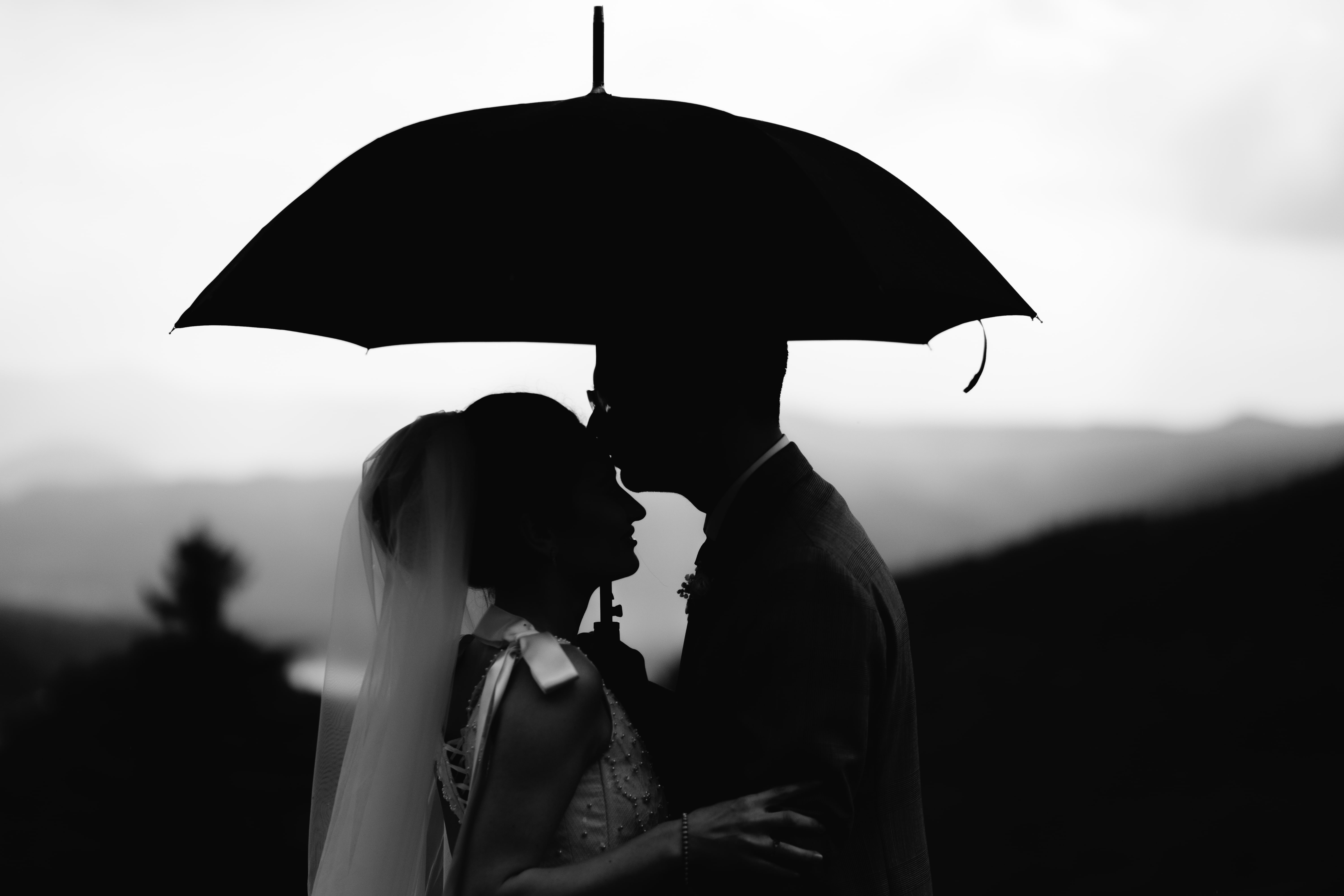 a man and woman kissing under an umbrella