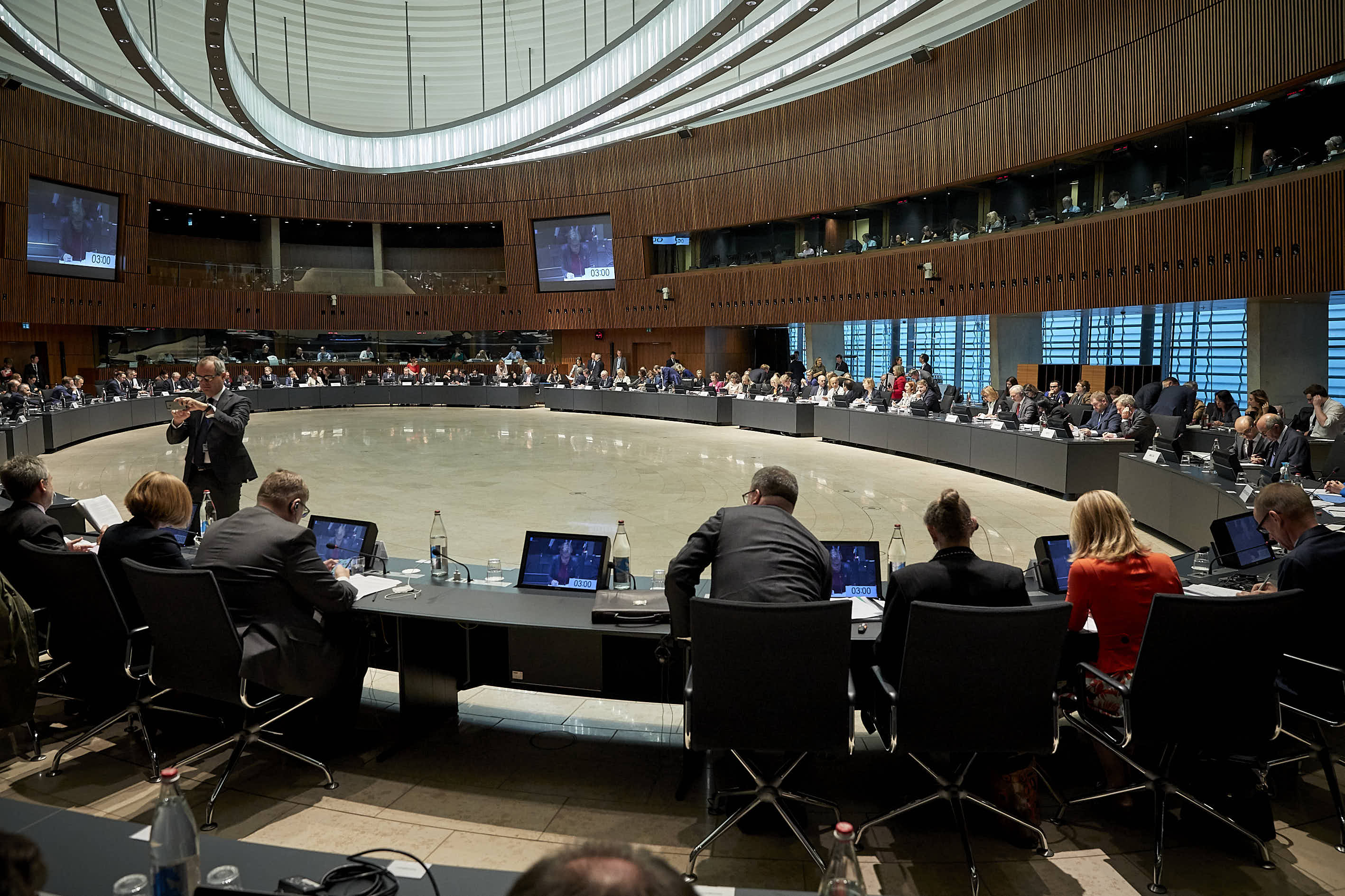 a group of people sitting in front of computers in a room with a large crowd of people