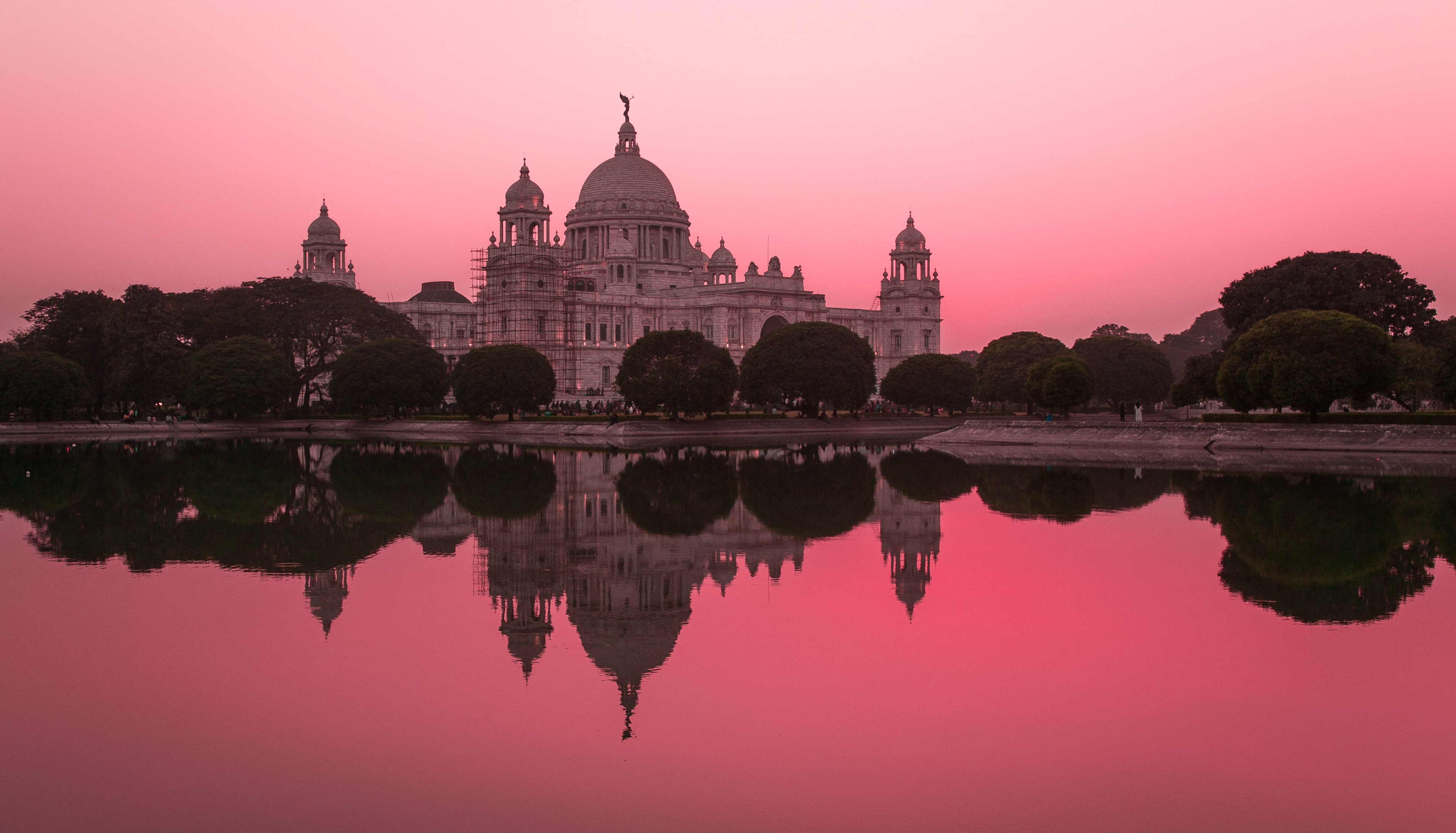 a large building with a domed roof and a body of water in front of it