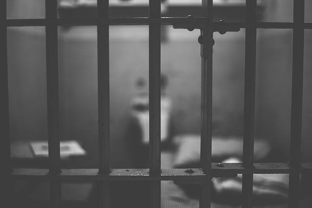 a black and white photo of a person in a jail cell