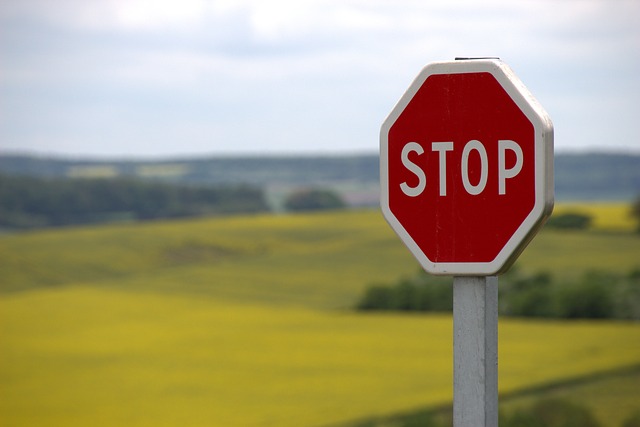 a stop sign in front of a field