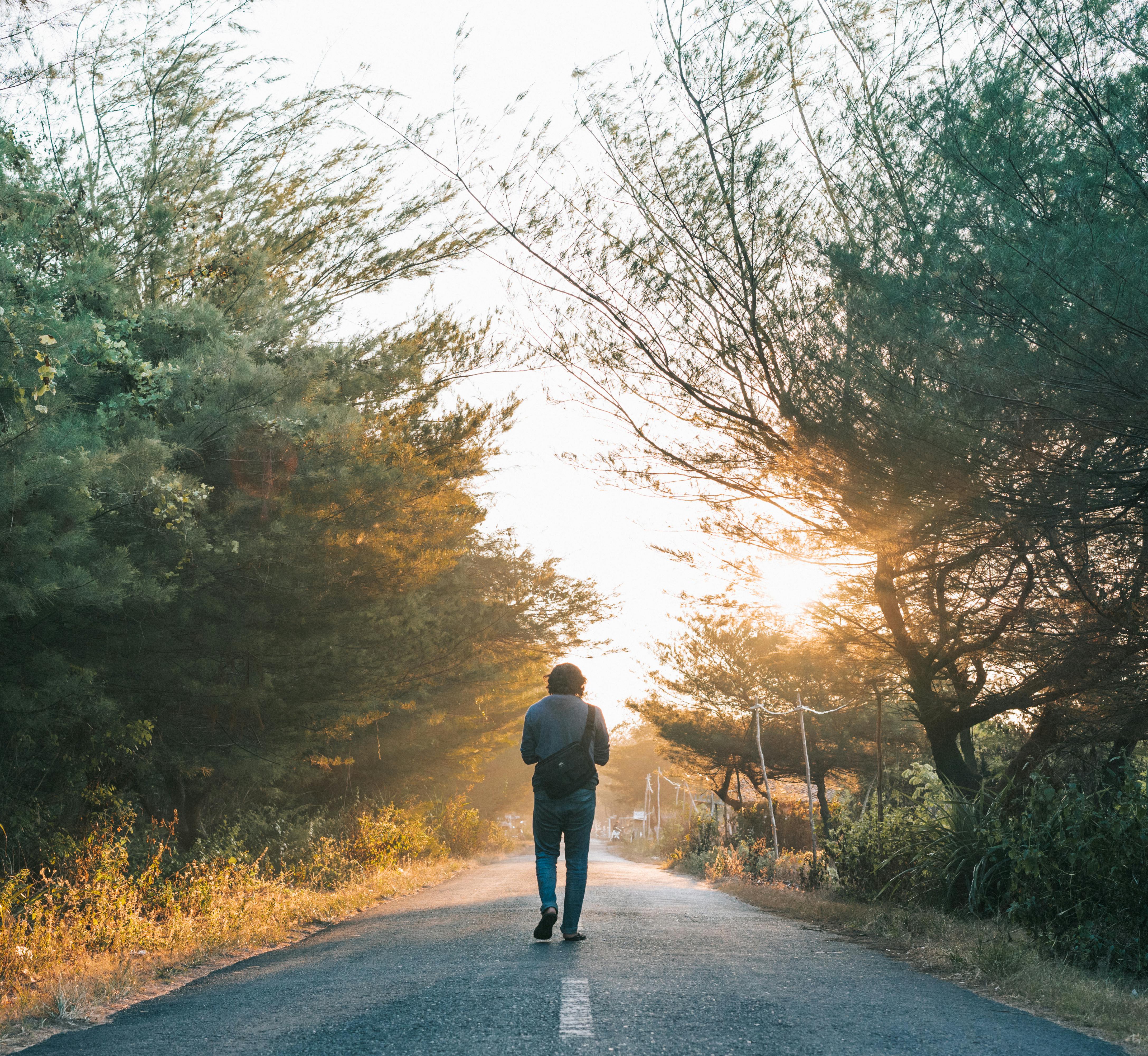 Man walking down the middle of a road.