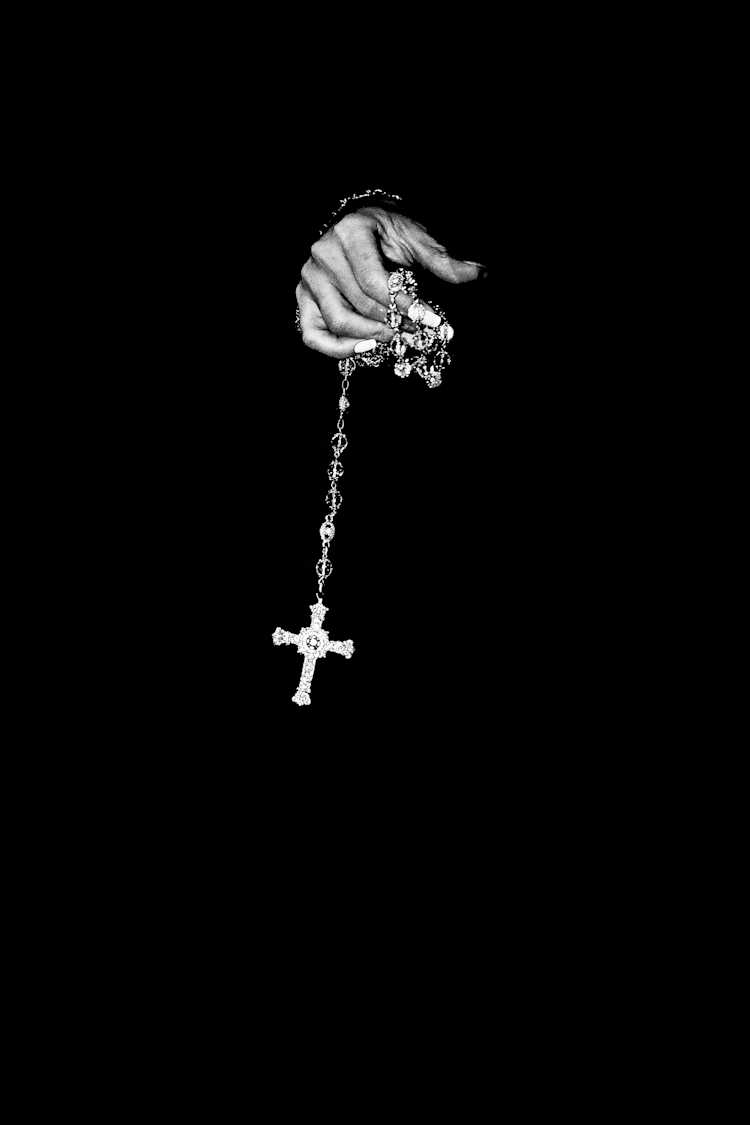 Man holding a chain with a cross on it