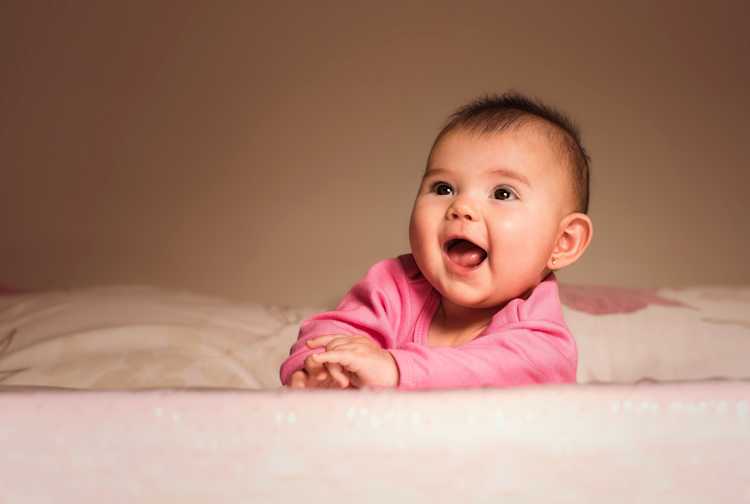 Smiling baby in pink laying down