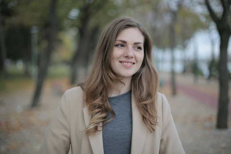 Joyful young modest woman walking alone in a park