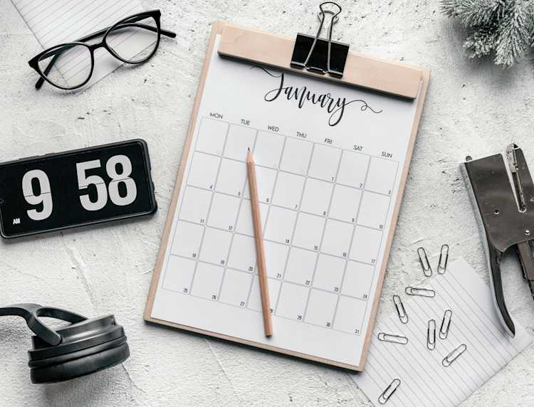 Clipboard with calendar placed on desk amidst stationery.