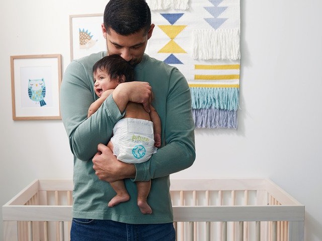 Photo of man holding baby wearing a diaper