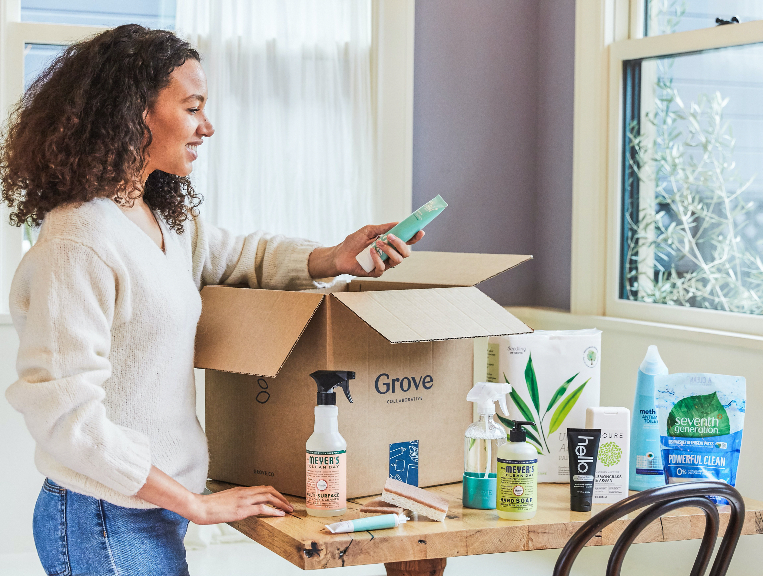 Image of a woman unboxing cleaning supplies from Grove.
