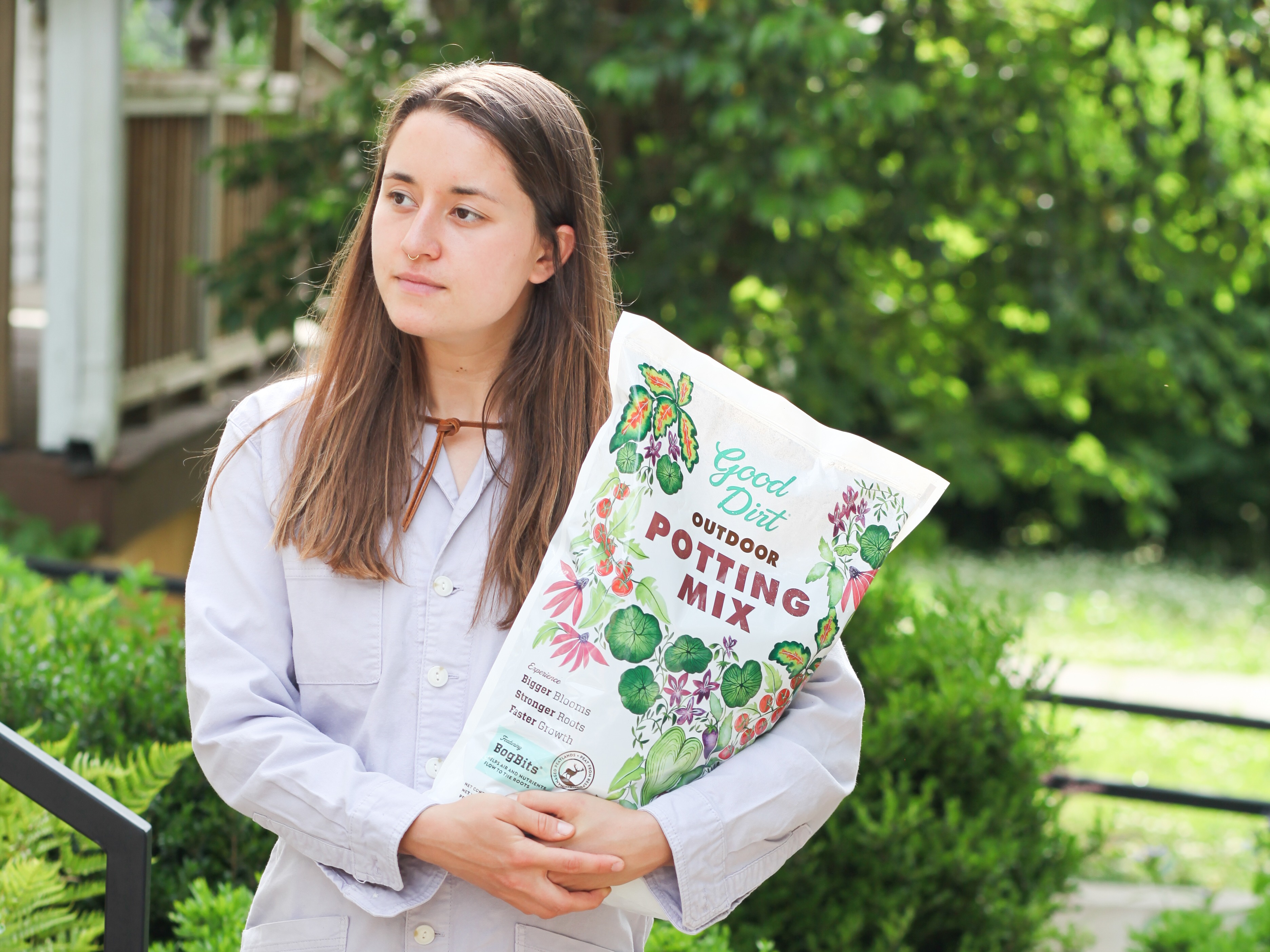 Woman holding Good Dirt Outdoor Potting Mix bag outside