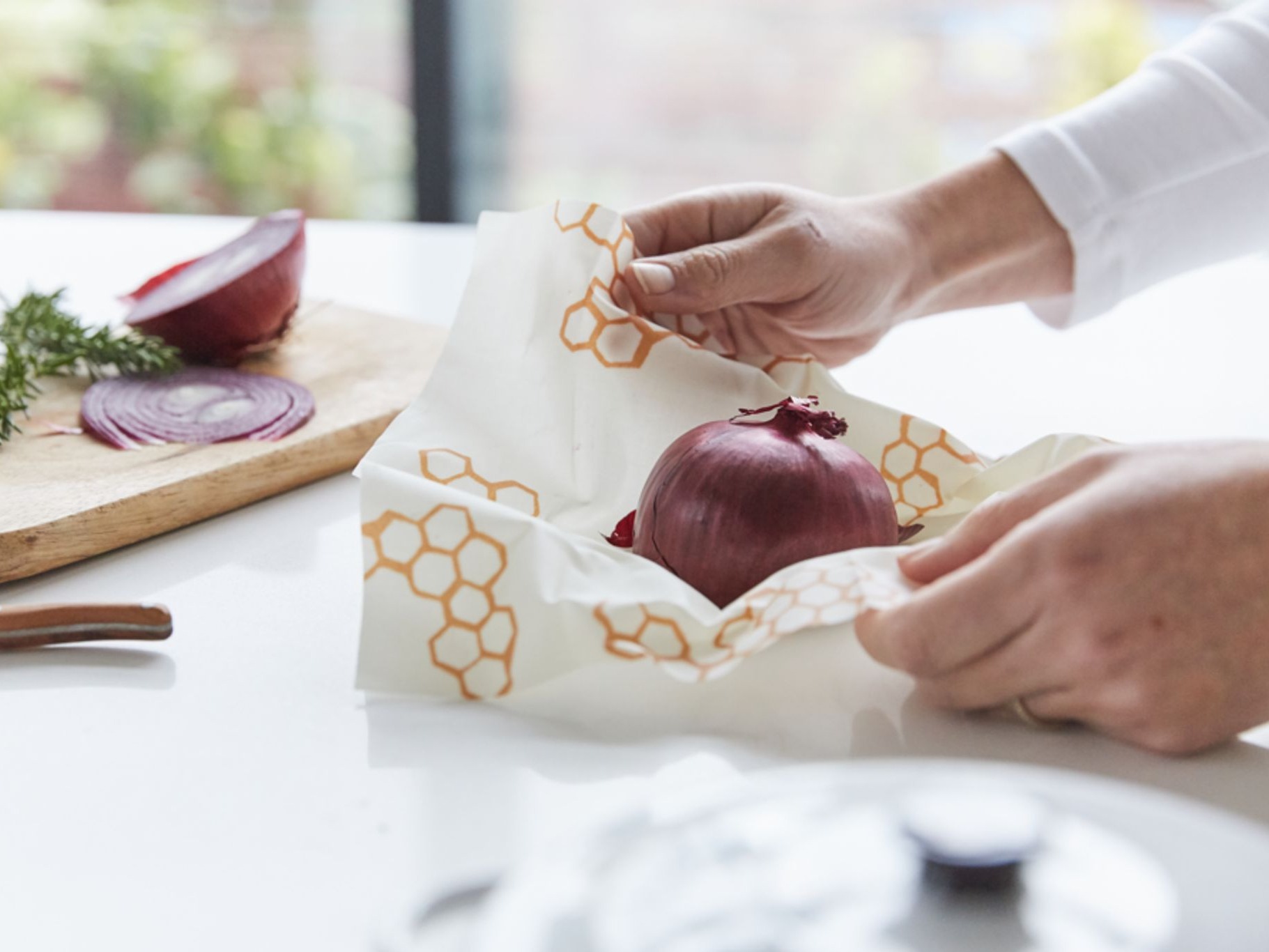 Photo of person wrapping onion in bee's wax wrap