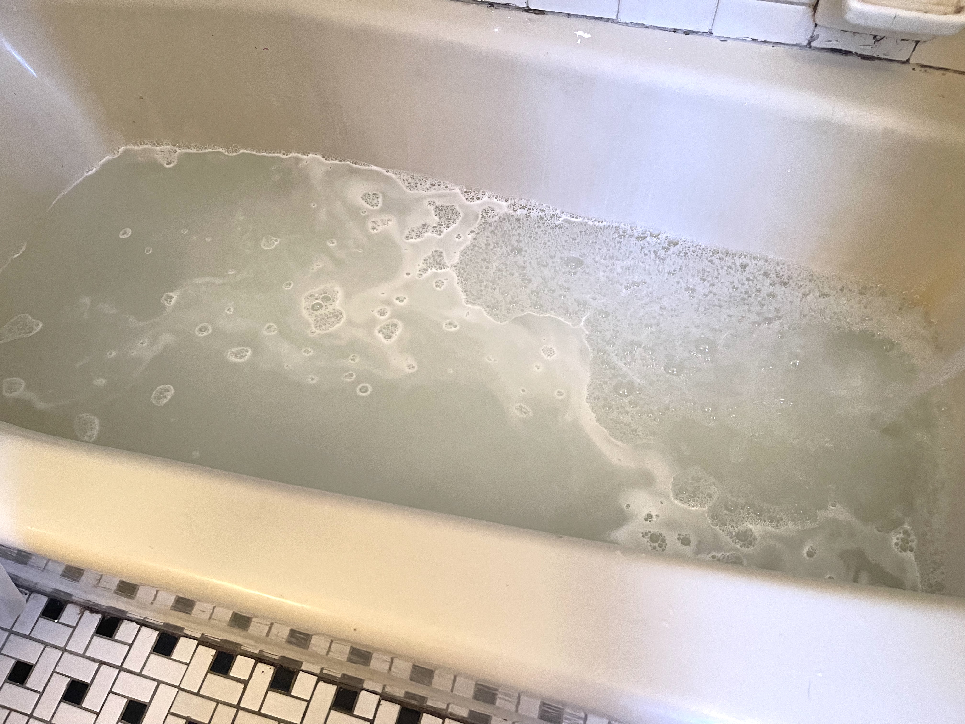 a sudsy bathtub prepared for laundry stripping.
