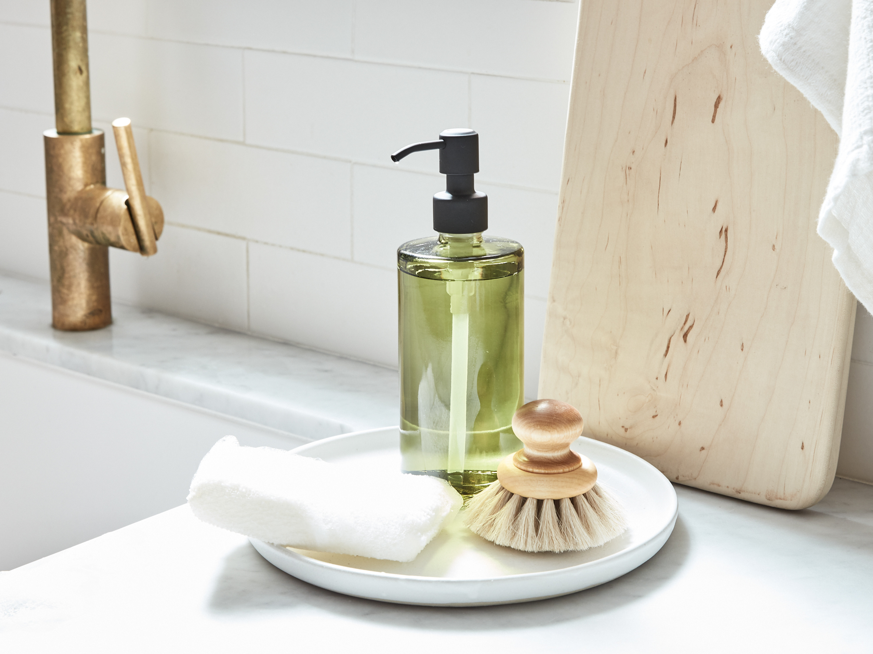 Natural cleaning products displayed on a kitchen counter by the sink.