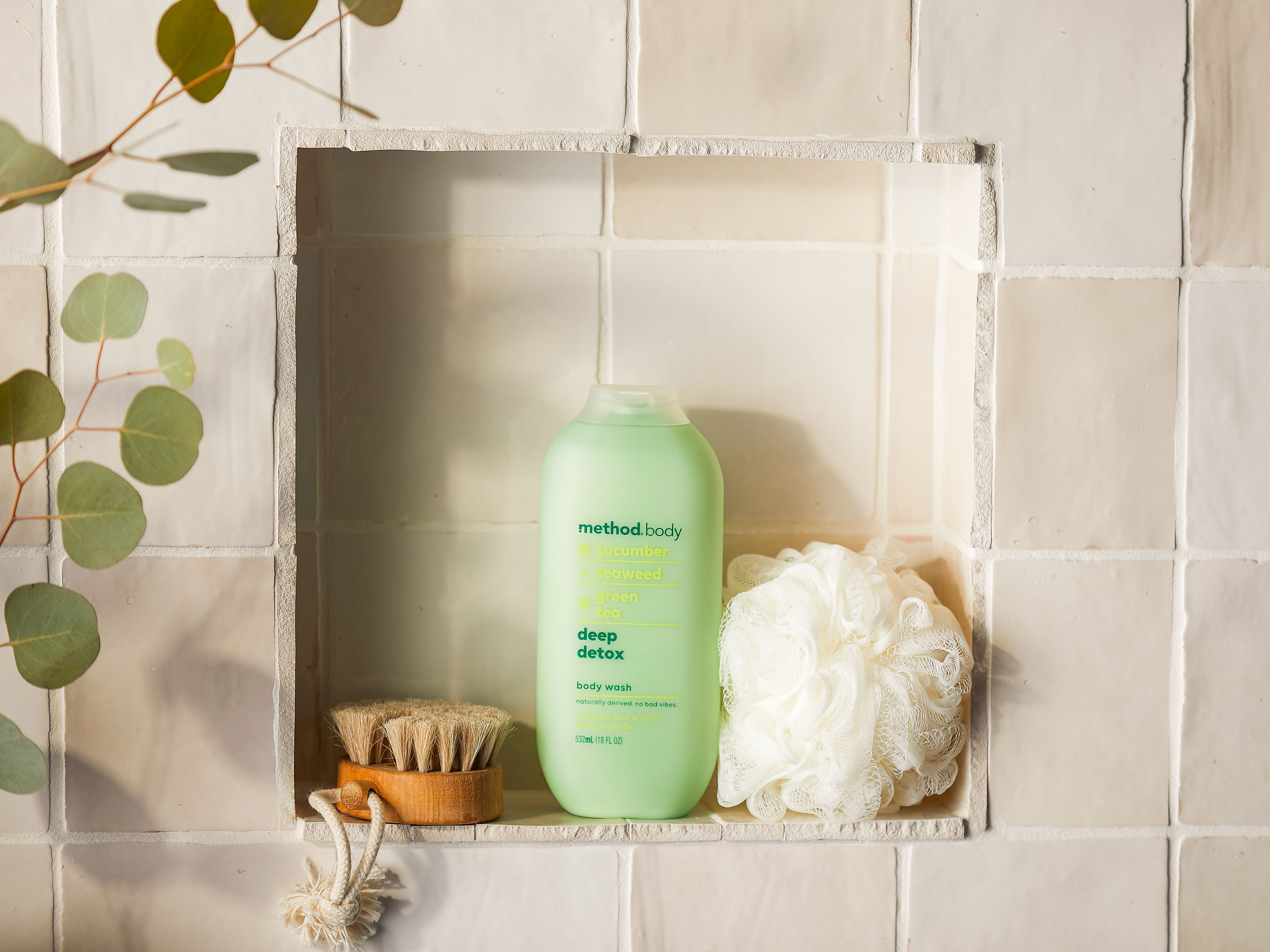 Image of Method green tea bodywash on shower shelf with loofah and brush