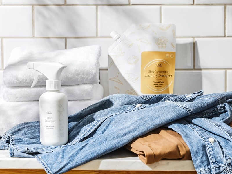 Image of denim shirt and folded towels next to laundry detergent and stain remover