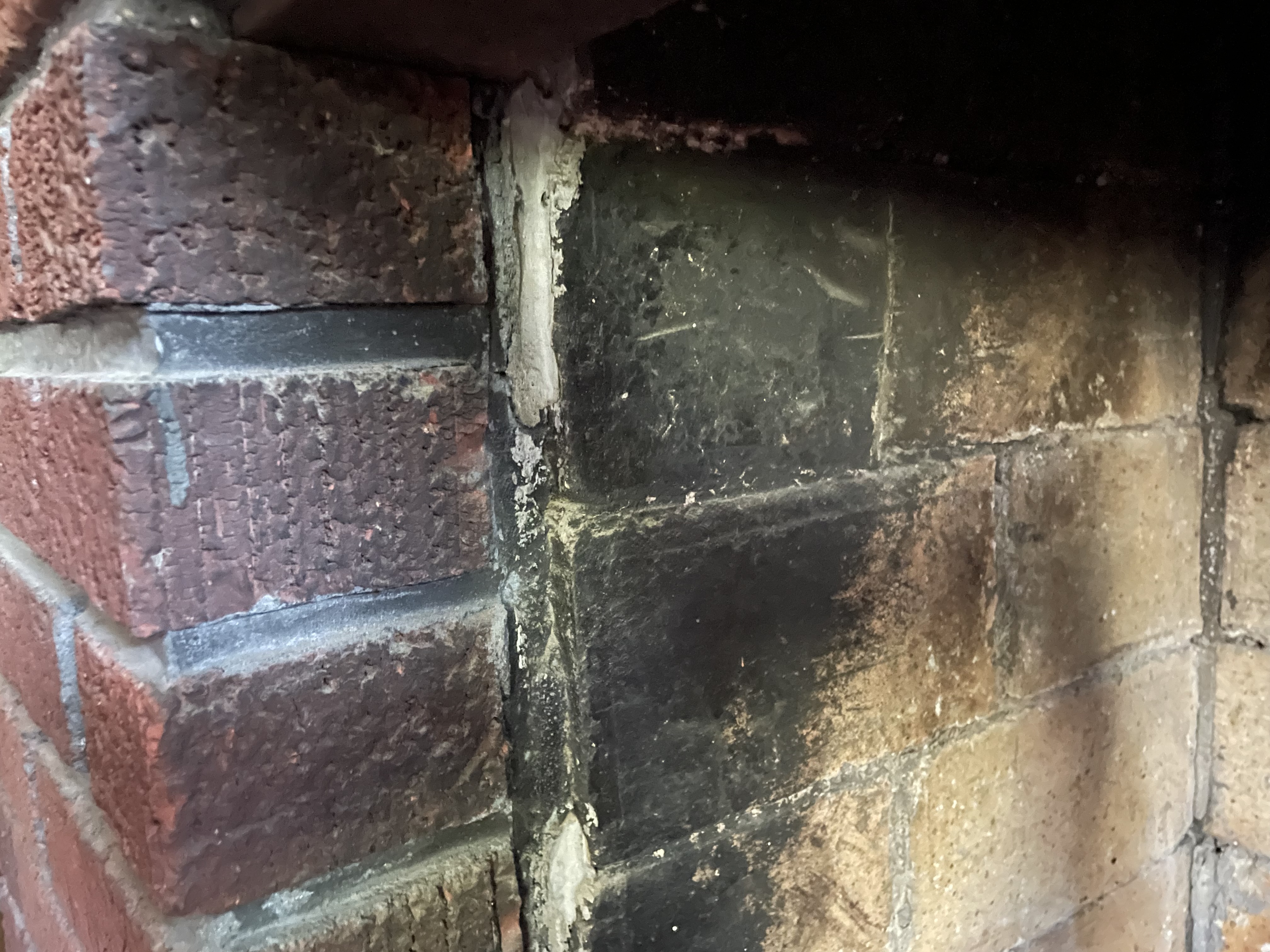 a closeup of the fireplace bricks creosote before they are cleaned