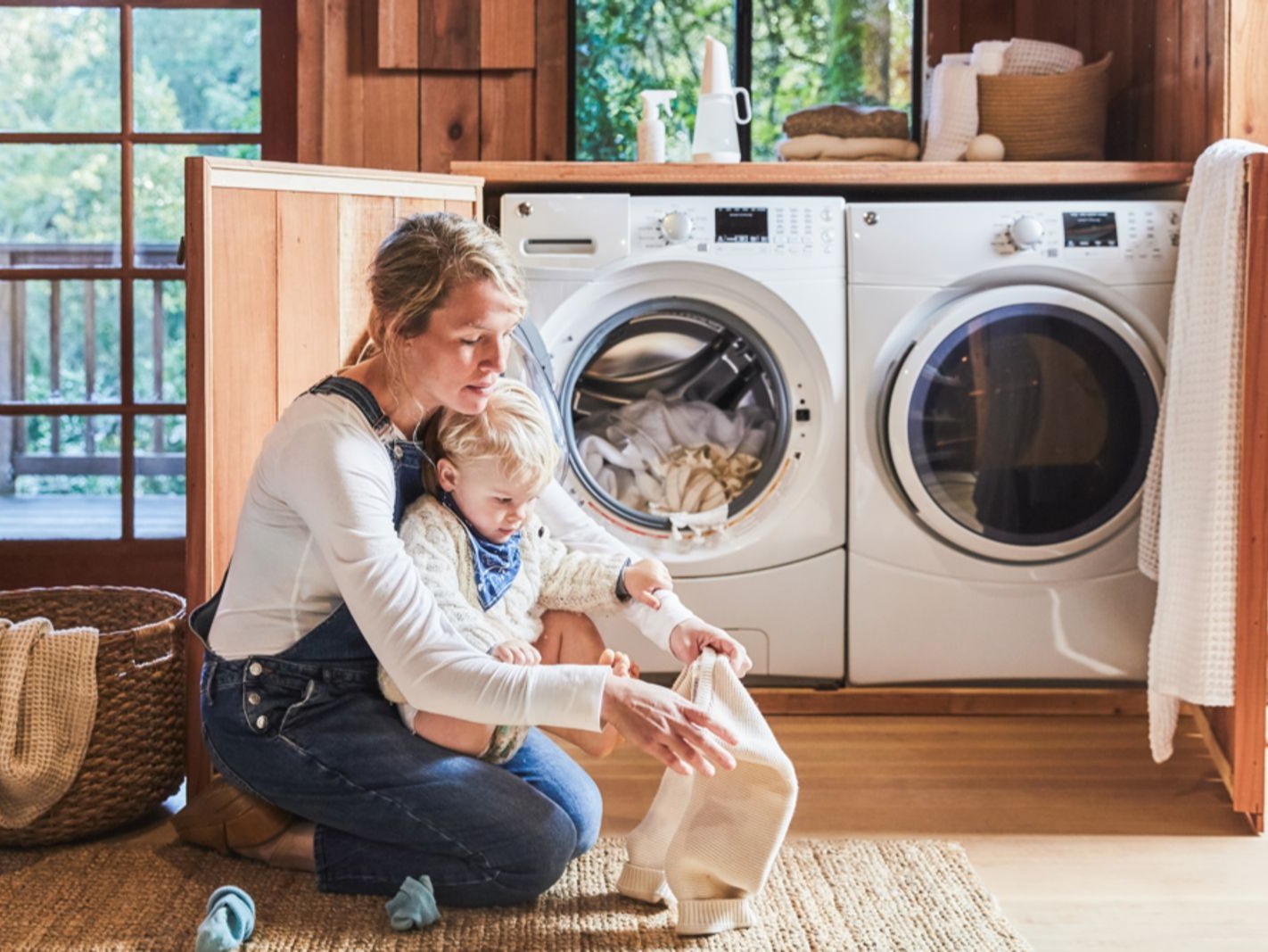 Photo of woman and child in front of washing machine and dryer