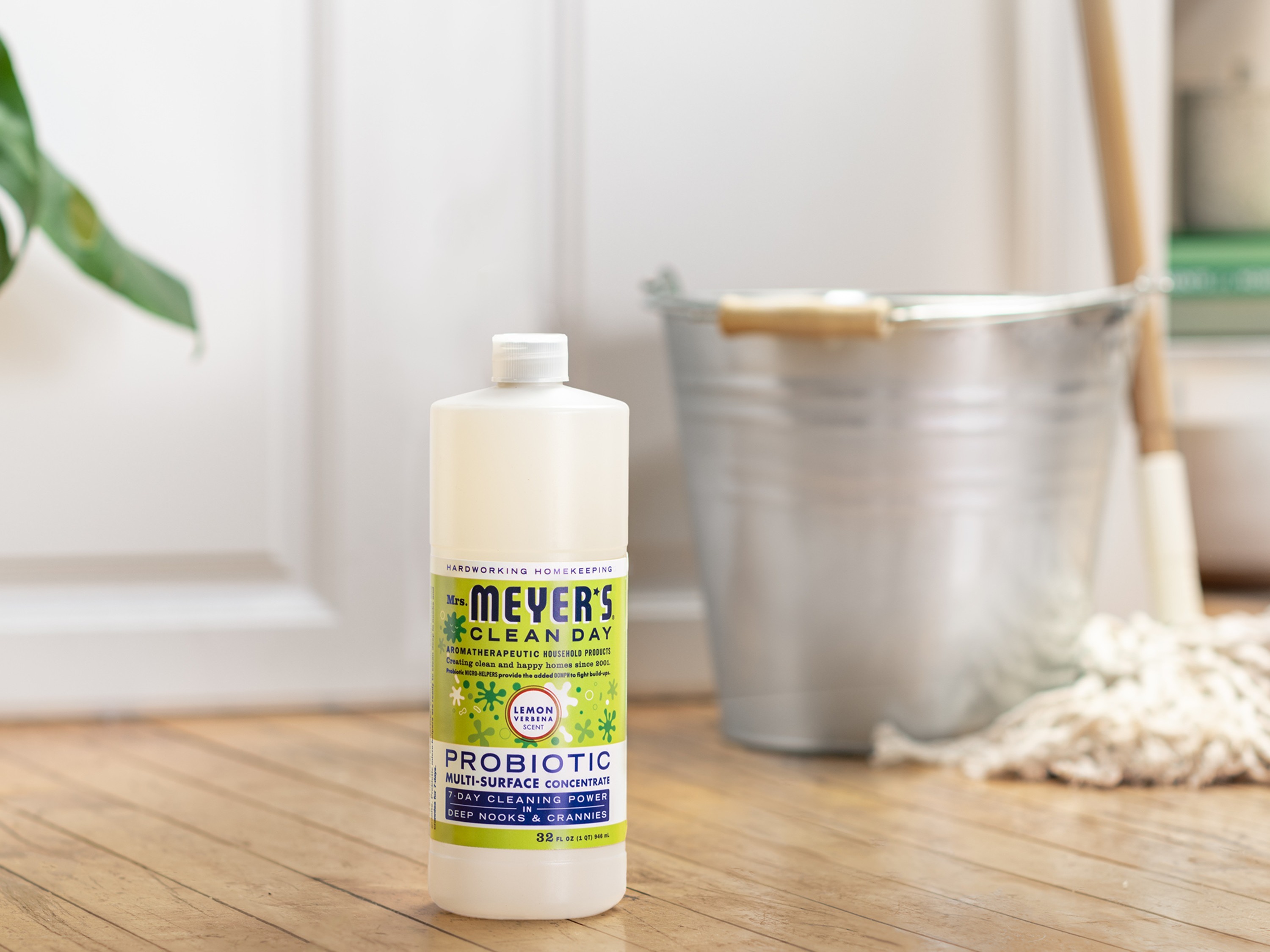 mrs meyers probiotic floor cleaner on wood floor by a mop and bucket