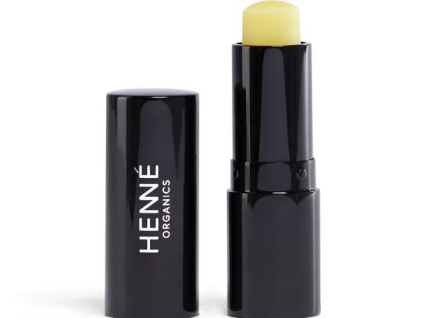 Henne Lip Balm with lid off standing next to balm