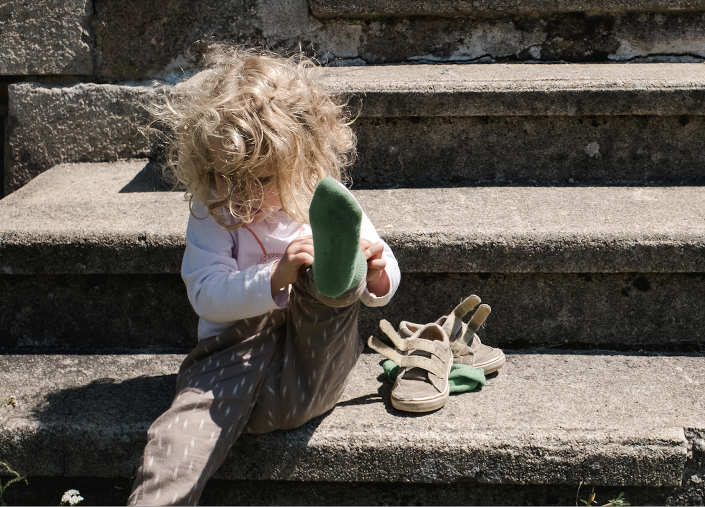 Image of a child next to a pair of velcro shoes