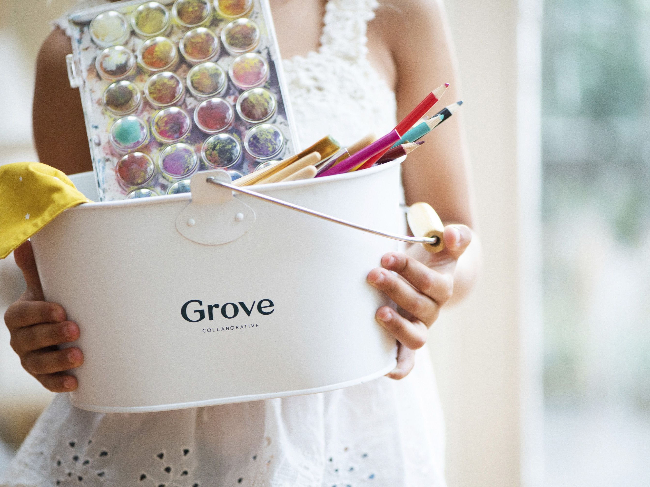 person holding Grove caddy with ink and coloring supplies